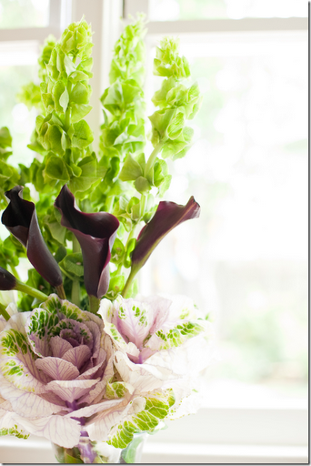 black cala lilies bells of ireland and pink cabbage arrangement